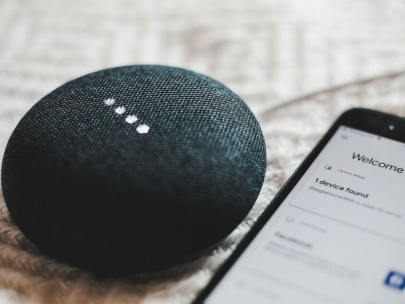 Google Nest Mini naast smartphone
