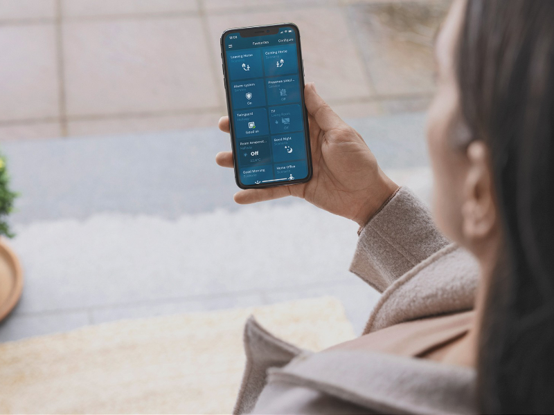 Bosch Smart Home instellen via je smartphone foto over de schouder van een vrouw die de Bosch Smart Home app via haar smartphone bedient