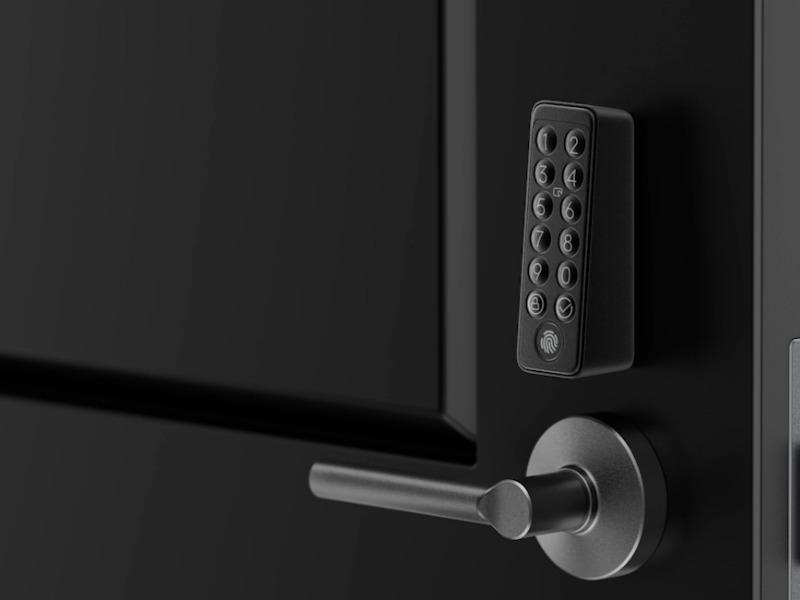 Een close-up van een zwarte deur met een modern, slim deurslot bestaande uit een cijfertoetsenbord met vingerafdrukscanner en een zilverkleurige deurklink.