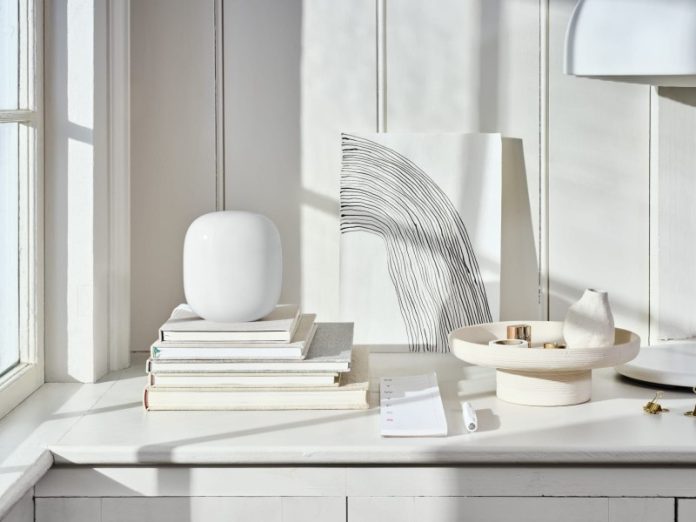 Een wit, modern Wi-Fi access point op een stapel boeken, ideaal voor het oplossen van wifi problemen.