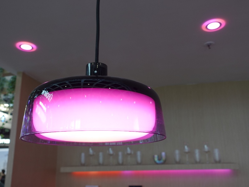 Govee Pendant Light, een glanzende zwarte hanglamp met een doorschijnende kap die een intens roze-paars licht uitstraalt.