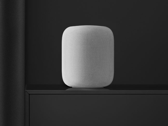Witte HomePod luidspreker met gaasstructuur staat inactief op een glanzend donkergrijs meubel, tegen een effen donkere achtergrond. Dit illustreert de melding 'HomePod reageert niet'.
