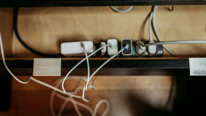Volle stekkerdoos met diverse adapters en kabels, een bekende bron van sluipverbruik.
