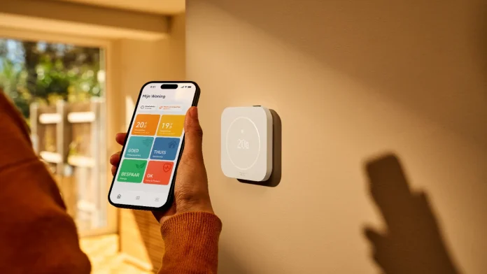 tado slimme thermostaat aan de muur bediend via een smartphone app voor een energiezuinig huis.