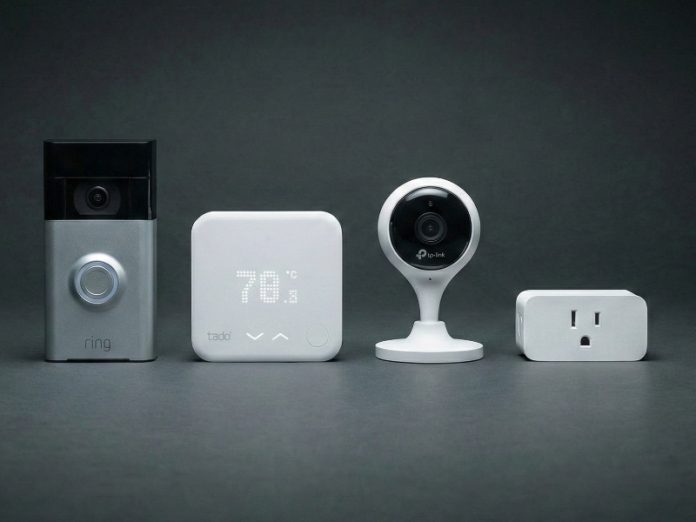 Vier Black Friday smarthome gadgets op een rij tegen een donkergrijze achtergrond: een zilverzwarte Ring deurbel, een witte Tado thermostaat, een witte TP-Link beveiligingscamera en een witte slimme stekker.