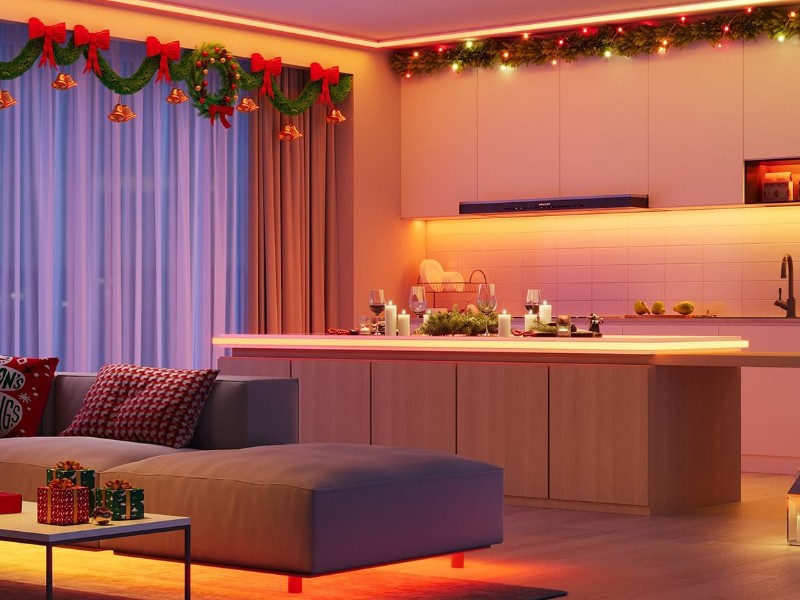 Feestelijk verlichte moderne woonkeuken met Govee RGBIC LED-strips. Warme rode en oranje gloed van de plafond- en kastverlichting creëert een kerstsfeer.