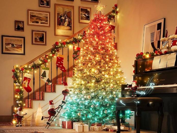 Een feestelijke kerstscène met een Govee kerstboom die een helder rood-oranje naar cyaan kleurverloop vertoont, wat de muzieksynchronisatie functionaliteit benadrukt.