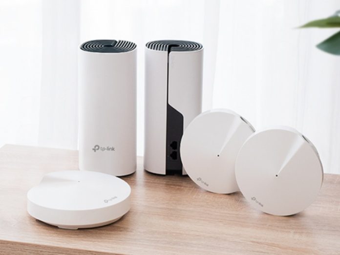 Witte TP-Link mesh Wifi-routers op een lichtbruine houten tafel, ideaal tegen een Wifi traag smart home.