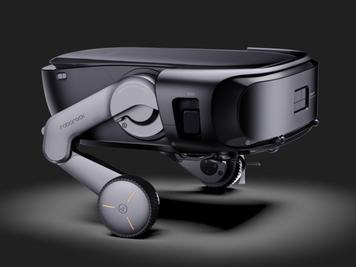 Strakke Roborock Saros Rover, diepzwart en donkergrijs, met gelede lichtgrijze poten. De wielen hebben een geprofileerd loopvlak en subtiele oranje lichtaccenten.