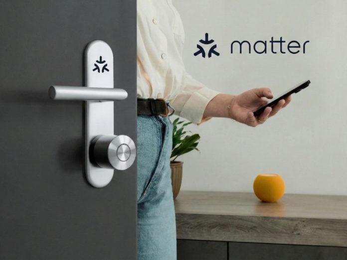 Een zilverkleurig slim deurslot met het donkerblauwe Matter-logo is gemonteerd op een donkergrijze deur, terwijl een persoon op de achtergrond een zwarte smartphone vasthoudt. Dit illustreert de integratie van de Beste Matter slimme sloten.