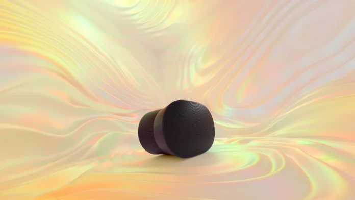 Een stijlvolle zwarte Sonos speaker staat centraal tegen een abstracte, golvende achtergrond van iriserende zijde in warme pastelkleuren.