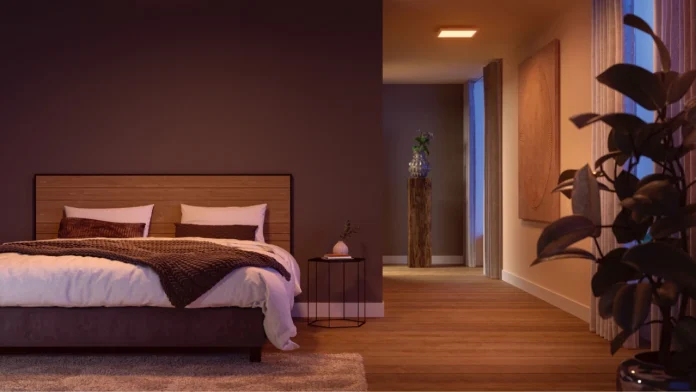 Een moderne slaapkamer met een houten hoofdbord en een warme, gouden hue van de verlichting die voor een rustgevende en gezellige sfeer zorgt.