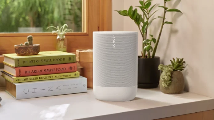 Een moderne witte Sonos speaker staat op een lichte plank naast een stapel boeken en sfeervolle kamerplanten in een zonovergoten interieur.