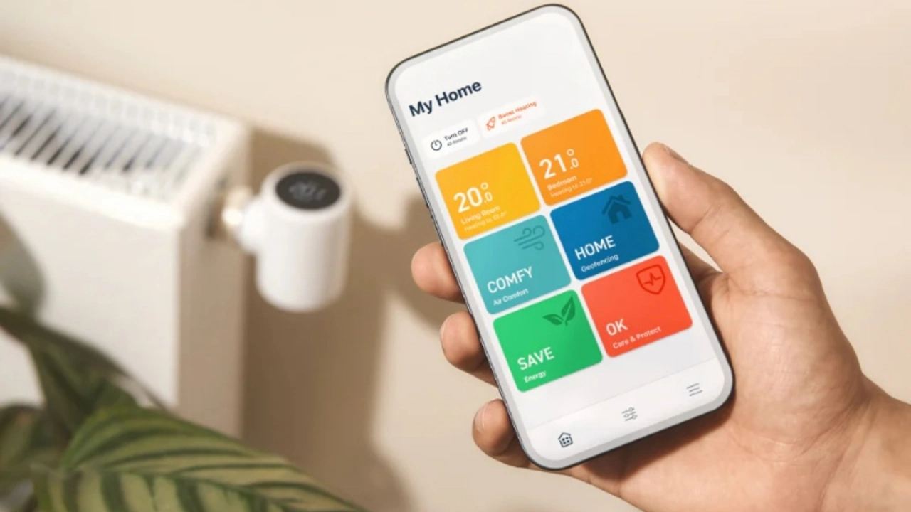 Een hand houdt een smartphone vast met de geopende tado app om de temperatuur van een radiator met een slimme thermostaatknop te regelen.