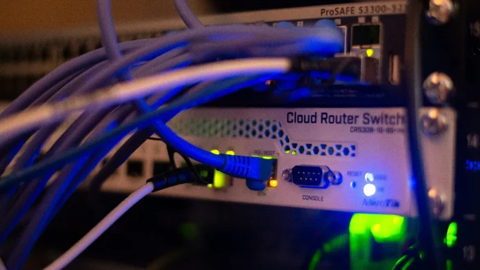 MikroTik cloud router switch met blauwe netwerkkabels in een datacenter serverrack.