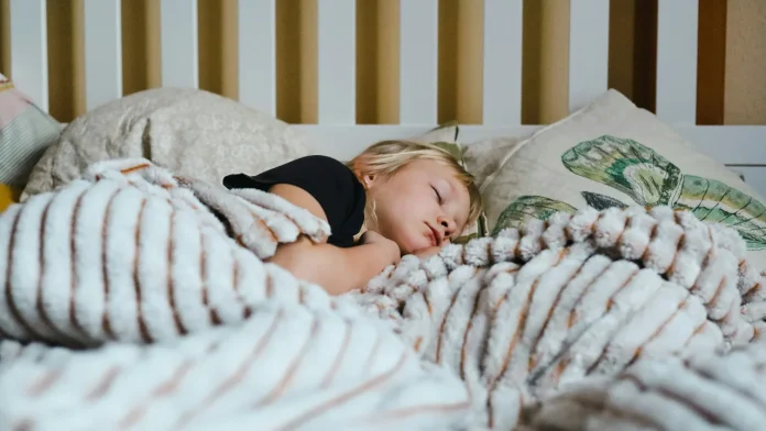 Meisje slaapt diep onder een zachte deken bij de ideale temperatuur slaapkamer.