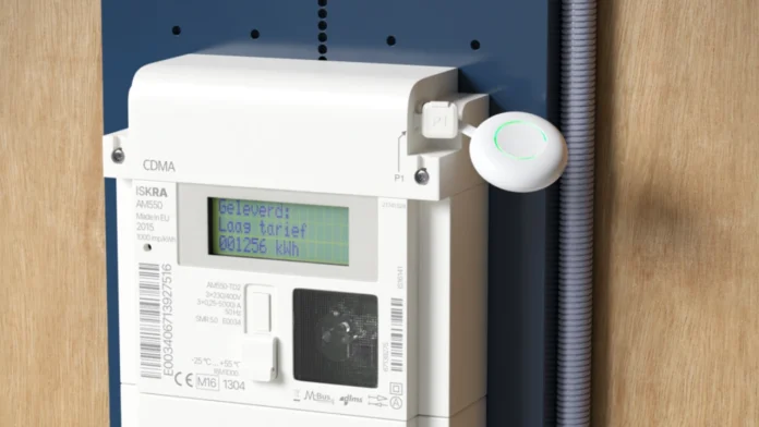 Een witte wifi-dongle met een groene lichtring is aangesloten op de P1-poort van een Iskra elektriciteitsmeter voor het real-time P1 meter uitlezen slimme meter.