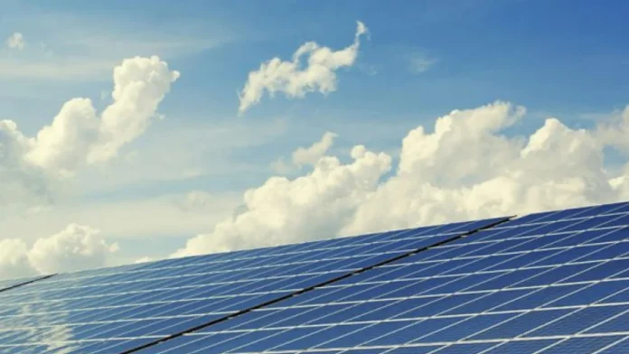 Blauwe solar panelen onder een heldere lucht met witte wolken voor duurzame energie.