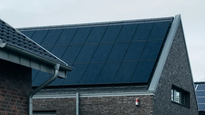 Moderne woning met een dak vol zwarte solar panelen voor duurzame energie.