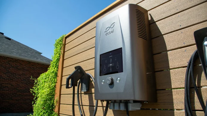 Moderne dcbel thuisbatterij en laadstation aan een houten wand voor duurzame energieopslag.