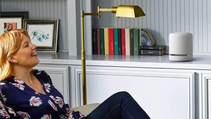 Lachende vrouw in een stijlvol interieur met een witte Amazon Echo smart speaker.