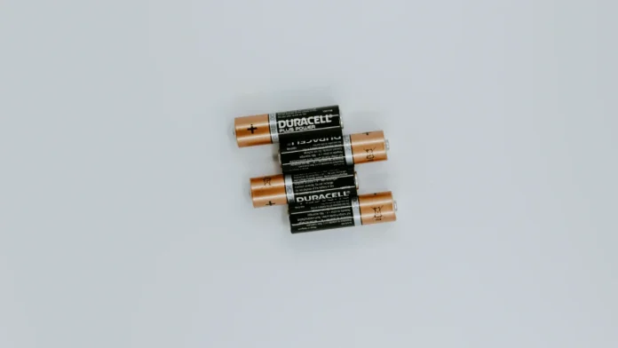 Vier Duracell batterijen horizontaal gestapeld op een witte achtergrond.