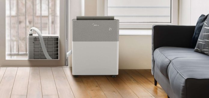 Stijlvolle Midea mobiele airco met digitaal display in een moderne woonkamer bij het raam.