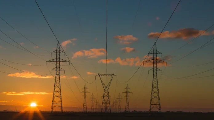 High-voltage power lines and transmission towers at sunset, providing reliable energie to the power grid.
