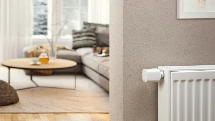 Eve slimme radiatorthermostaat op een witte radiator in een moderne woonkamer.