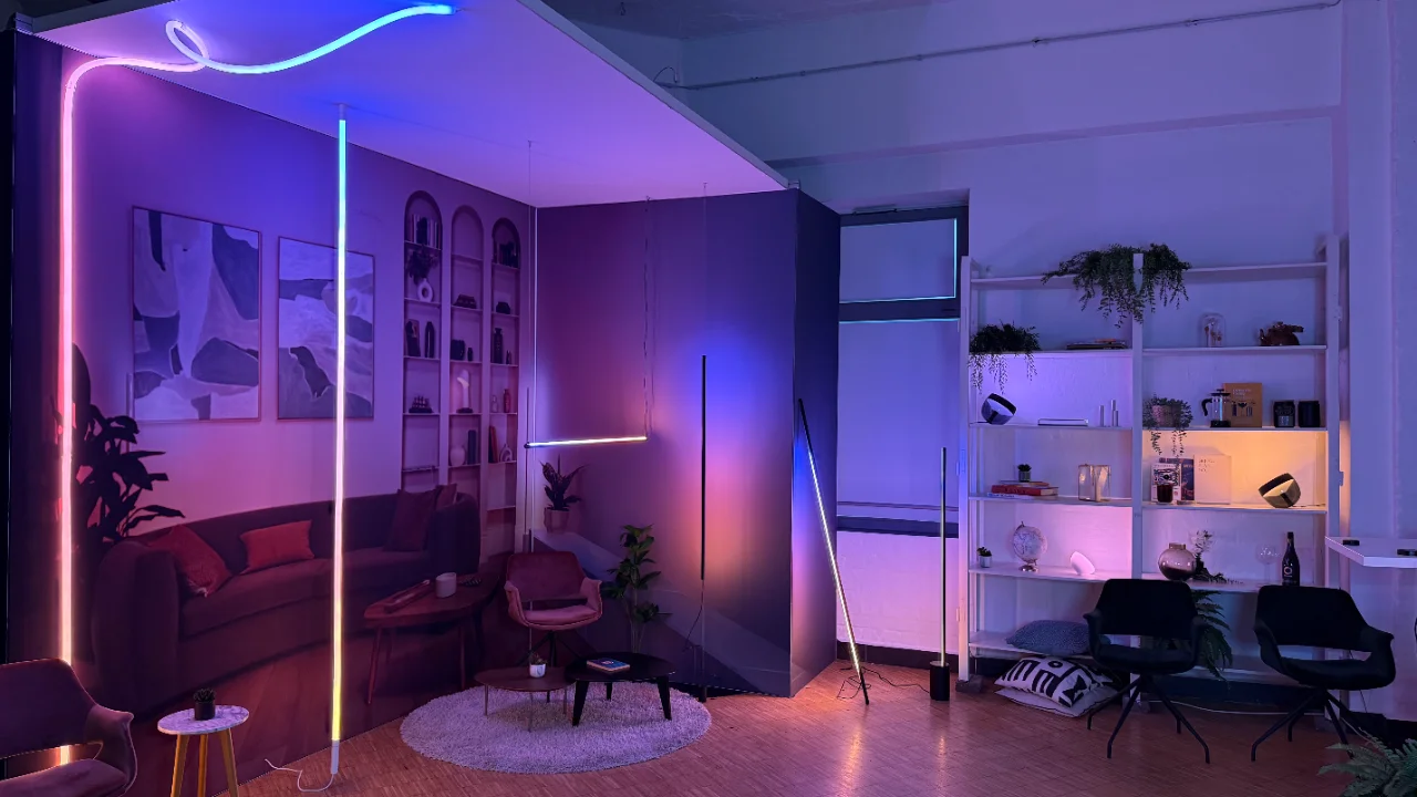 Vibrant hue smart lighting illuminates a modern living room with colorful neon strips and ambient floor lamps.