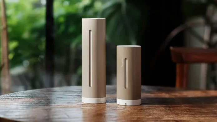 Netatmo weerstation met binnen- en buitenmodule op een houten tafel voor een groene achtergrond.