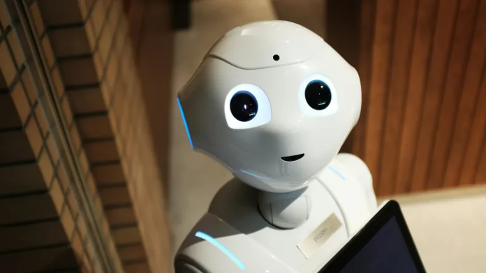 Witte humanoïde robot met grote ogen en een tablet voor interactie.