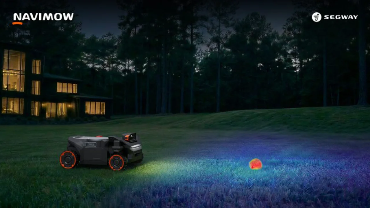 Segway Navimow robotic lawn mower using obstacle detection technology on a lawn at night.
