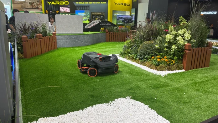 Segway Navimow robotic lawn mower on artificial grass in a garden exhibition display.