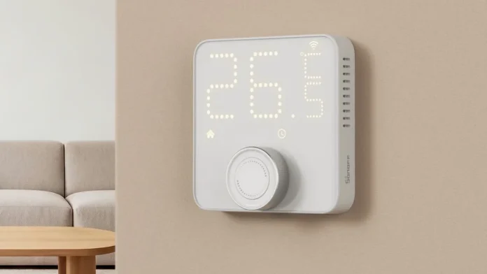 Witte Sonoff slimme thermostaat met draaiknop en digitaal display gemonteerd op een beige muur.