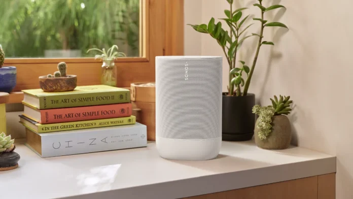 Witte Sonos speaker op een dressoir naast kookboeken en kamerplanten.