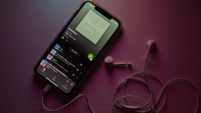 Spotify-afspeellijst op een iPhone met witte oortjes en paarse sfeerverlichting.