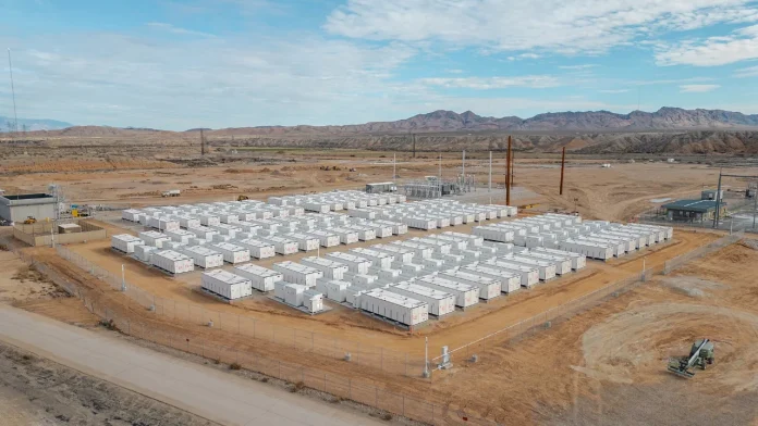 Luchtfoto van grootschalige batterijopslag: rijen witte batterijcontainers in een open landschap