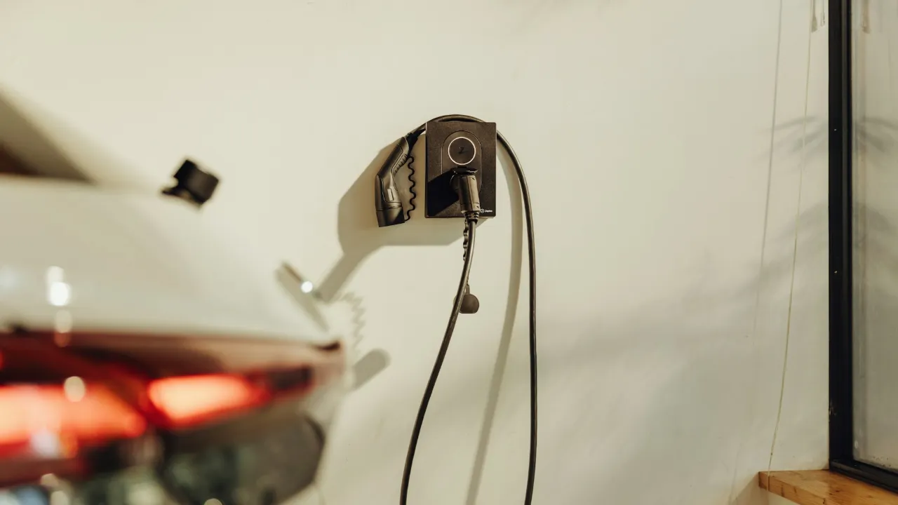 Elektrische auto aangesloten op een wallbox aan de muur van een garage
