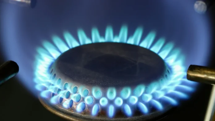 Close-up van een blauwe gasvlam op een gasfornuis.