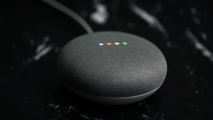 Slimme speaker van Google met gekleurde lichtjes op een donker oppervlak