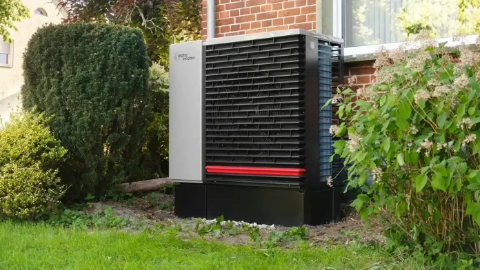 Buitenunit van een hybride warmtepomp naast een bakstenen woning