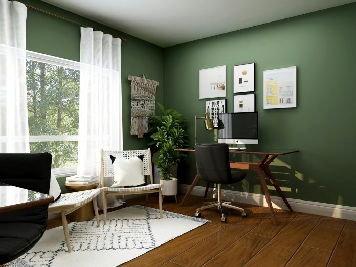 Lichte thuiswerkplek met groene muur, bureau en groot raam