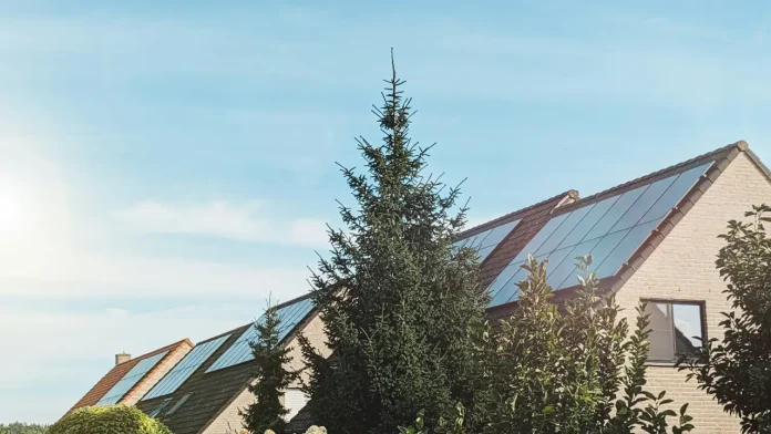 Rijtjeshuizen met zonnepanelen op het dak onder een blauwe lucht: zonnepanelen zonder saldering